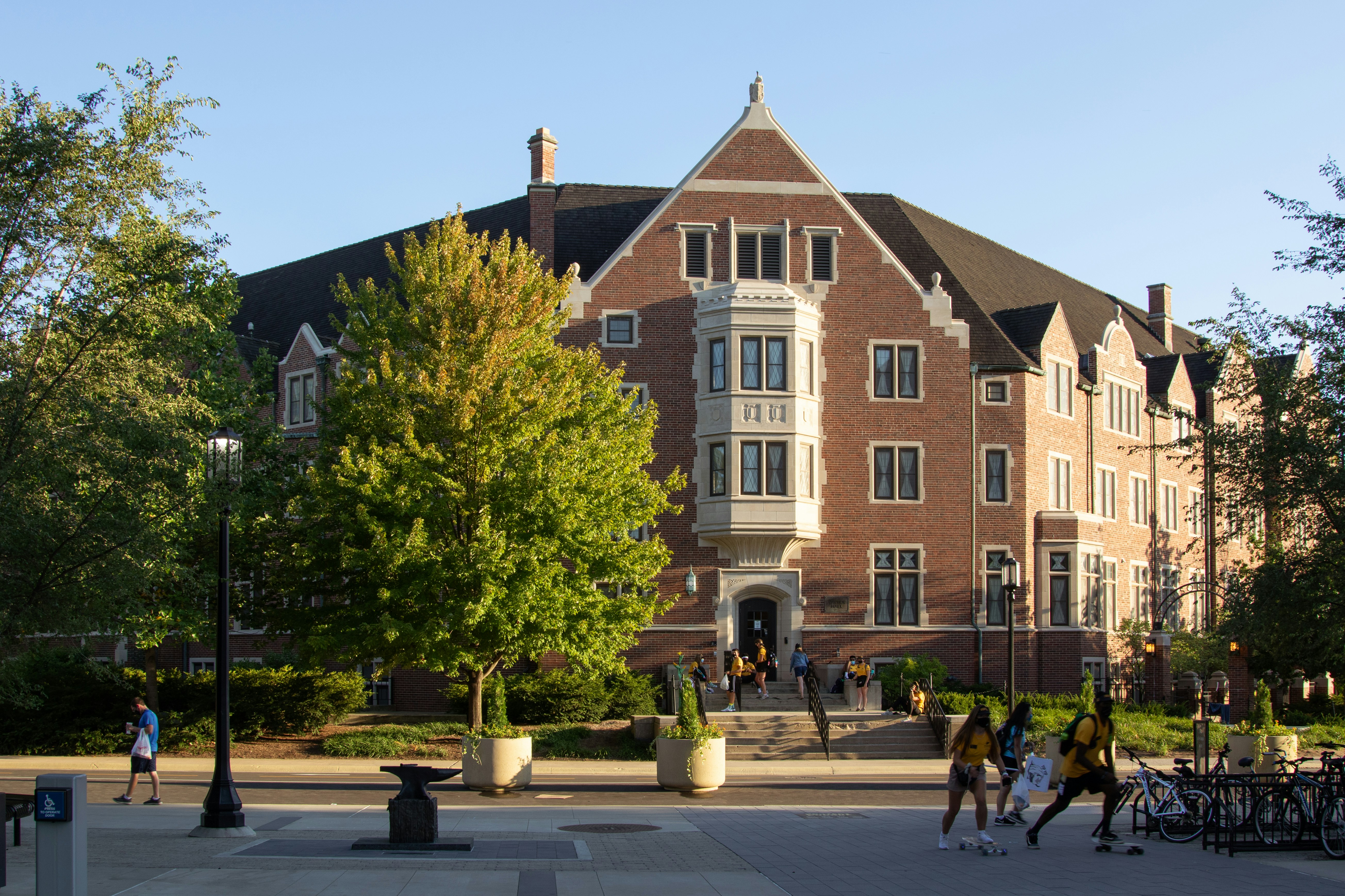 Students walking on a college campus near historic brick buildings