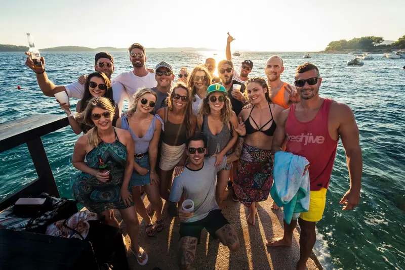 Group of students enjoying a sunny day on a freshwater beach, representing lake life at college