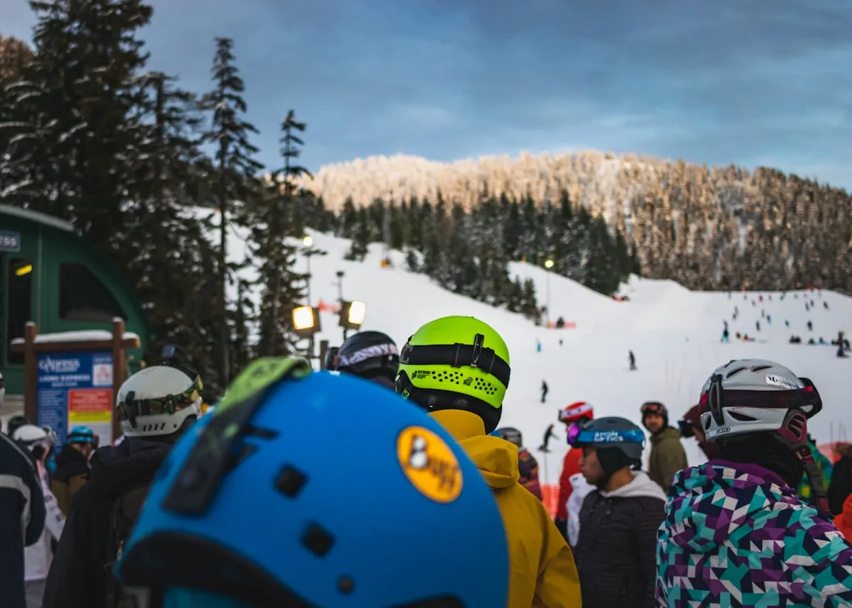 Two skiers descending a snow-covered slope through trees